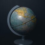 An antique world globe displayed on a dark black background, highlighting North America.