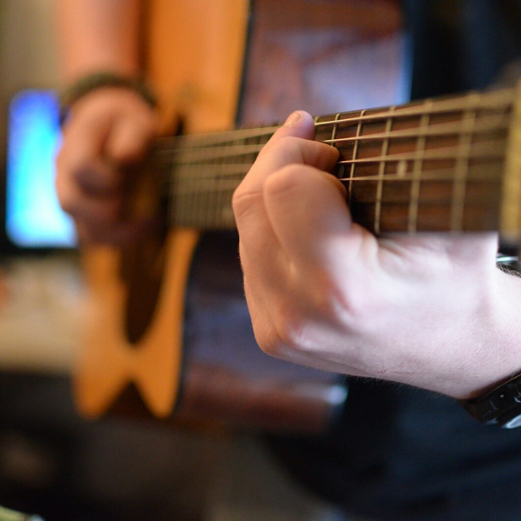 a person playing a guitar in a living room