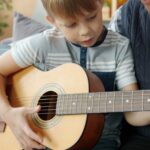 Boy learns guitar with grandfather's help